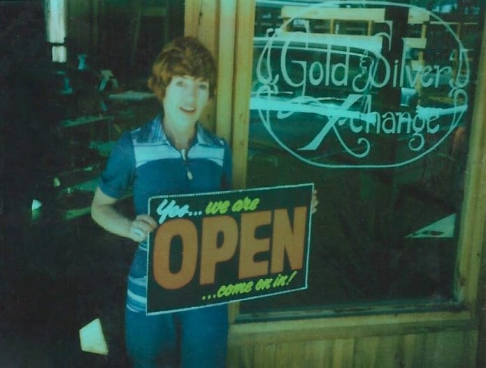 Darline Brown, founder of The Little Jewel, holding an Open sign at her first shop